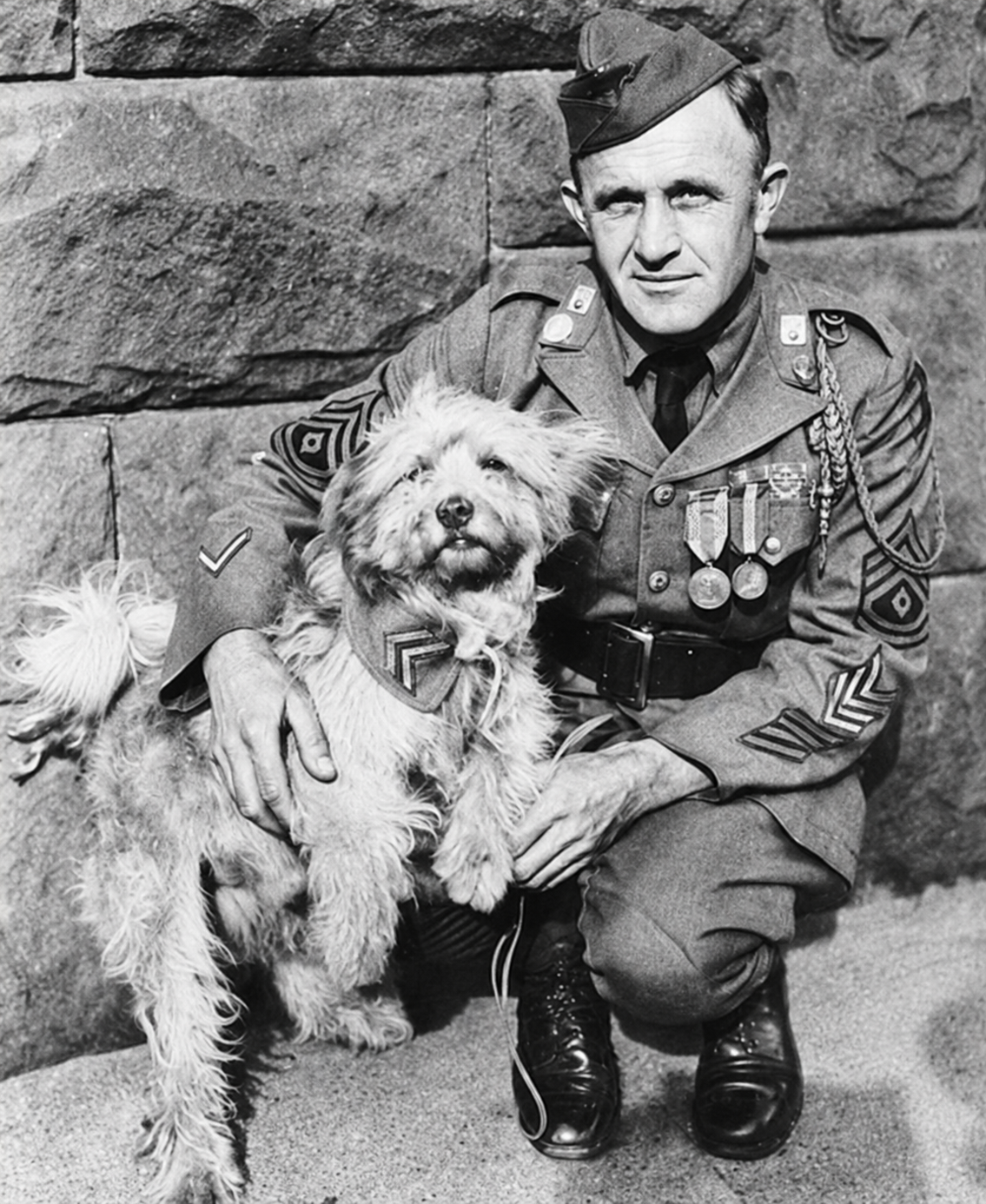 Historical black-and-white photograph of Sergeant George Hickman kneeling with Rags.